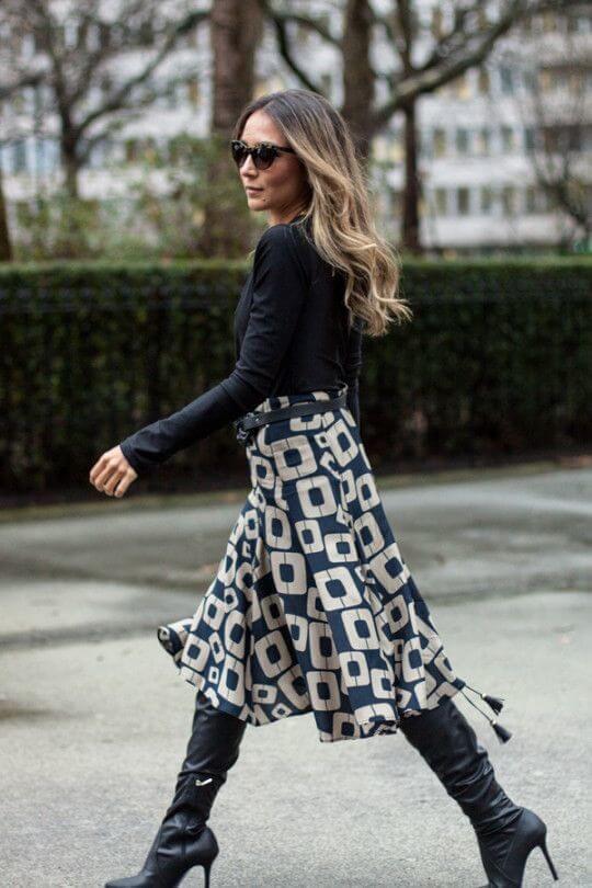 Navy blue boots matched with a printed navy-white midi skirt are perfect workwear inspiration