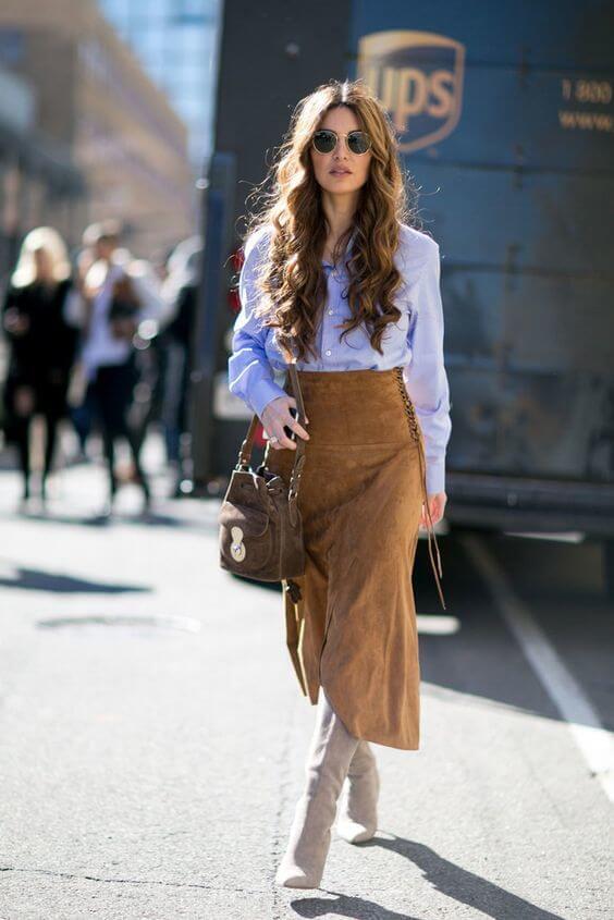 Add some bohemian vibes into your workwear with this brown suede skirt and fringes. Round everything off with a blue button-down and beige boots.