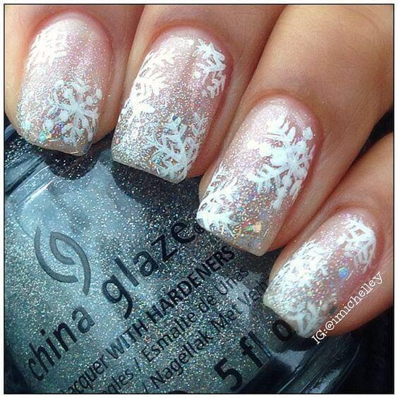 Sparkly nail polish and snowflakes on them will instantly bring you into the holiday spirit. #winternails #naildesign