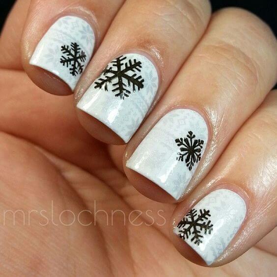 The classic white design is enriched with black snowflakes. Even if it sounds minimal, it is perfect for the winter season. #winternails #naildesign