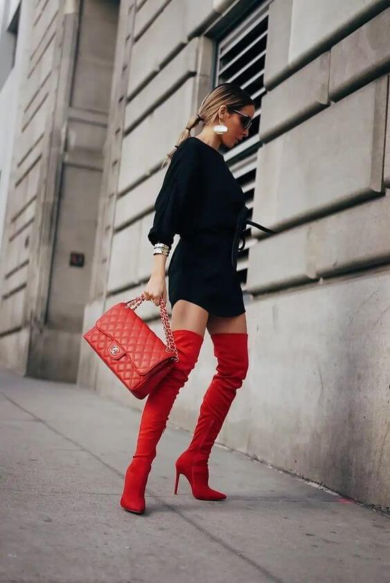 Make a dramatic appearance at the party by wearing red over-the-knee boots with the classic black dress. The red bag is the must-have to match with boots. #bootsoutfit #nighout #nightoutlook