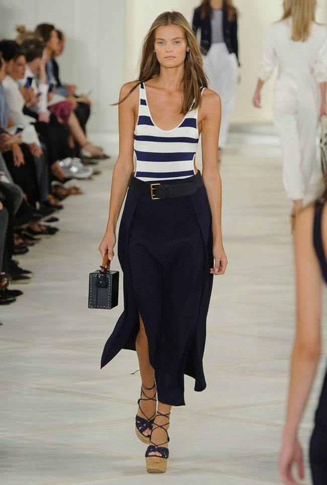 model in nautical theme: layered maxi skirt in navy blue with a striped navy and white vest. Nautical colored maxi skirt and striped vest.