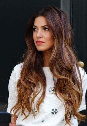 long wavy hair with reddish-brown lowlights and caramel highlights