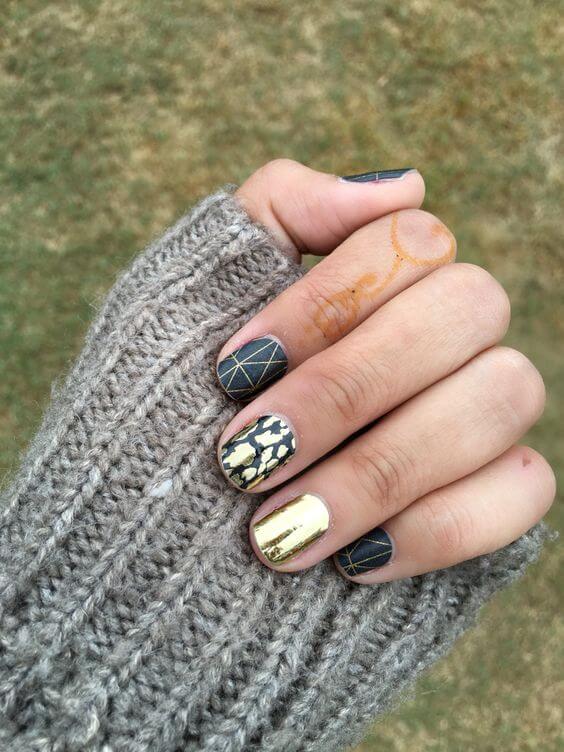 This artistic manicure uses three distinct patterns in black and gold.
