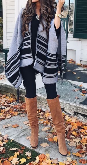 Woman in black leggings, gray poncho and brown boots