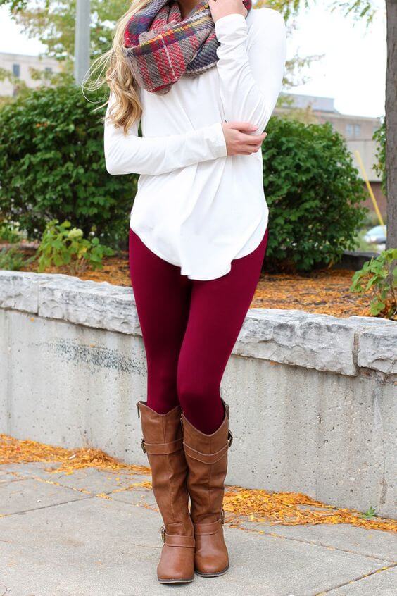 Woman wearing a white top, berry leggings, tartan scarf and brown boots