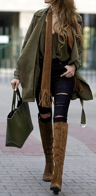 Woman wearing ripped black jeans, olive green top, olive green jacket, brown scarf, olive green handbag and brown boots