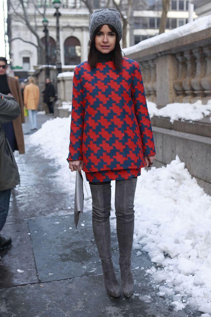 Miroslava Duma in a mod style printed dress, thigh high boots, and a knit beanie