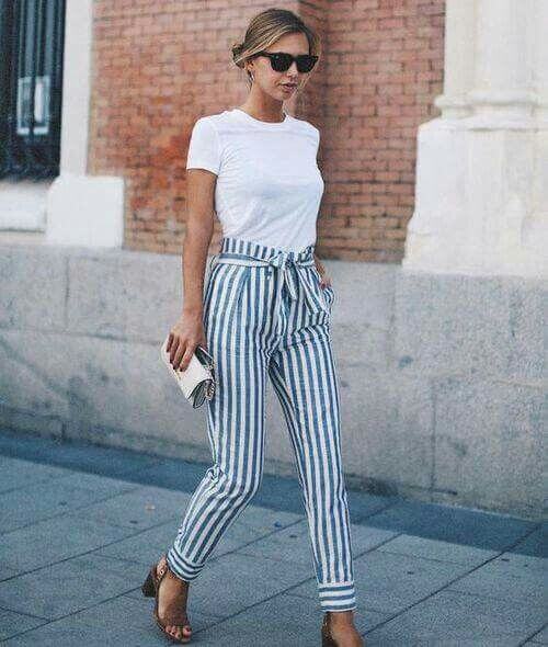Trendy blonde in white T-shirt and striped pants. A simple white T-shirt is elegant and striking when worn with classic stripes.