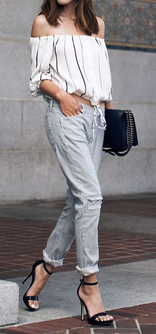 Trendy woman in striped off-the-shoulder top and striped pants