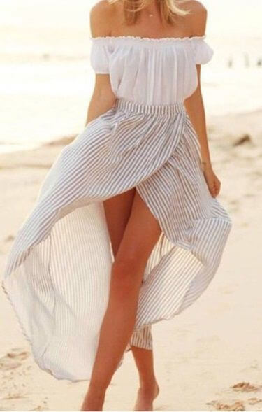 Woman on the beach in white off-the-shoulder top and striped wrap skirt