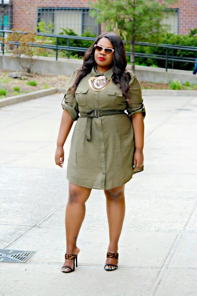 The military green dress is accented with a belt on the waist and statement-making necklace