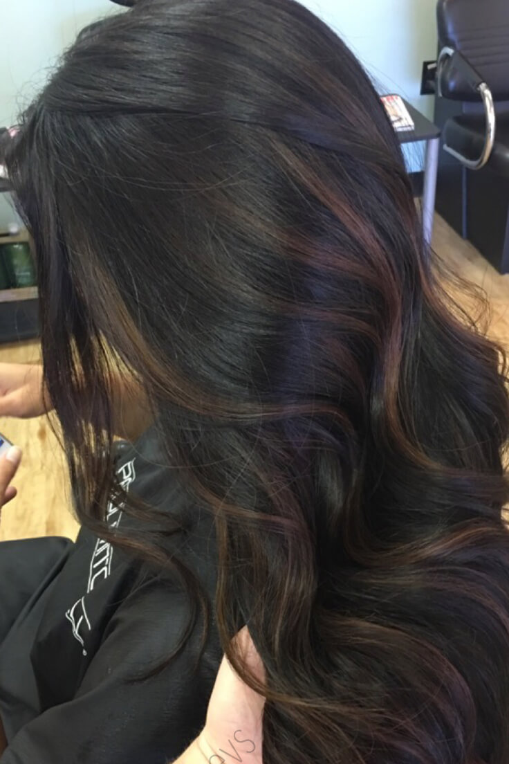 This model's wavy dark brown hair is ever so lightly highlighted with some subtle, light brown highlights