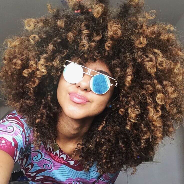 This gorgeous model is rocking all-over golden highlights in her naturally curly 'do.