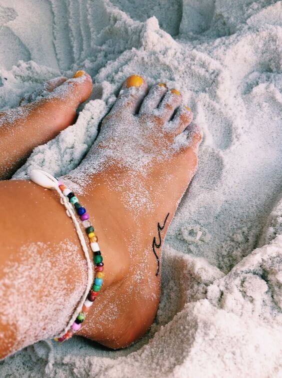Wave tattoo on the foot combined with a colorful jewelry - simple details can make a perfect beach look #summertattoo #minitattoo #minimalisttattoo