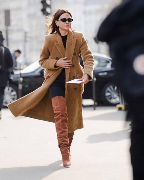This fashion editor matches the color of her boots with her lovely winter coat. You can do it with any other color. #highboots #winteroutfits