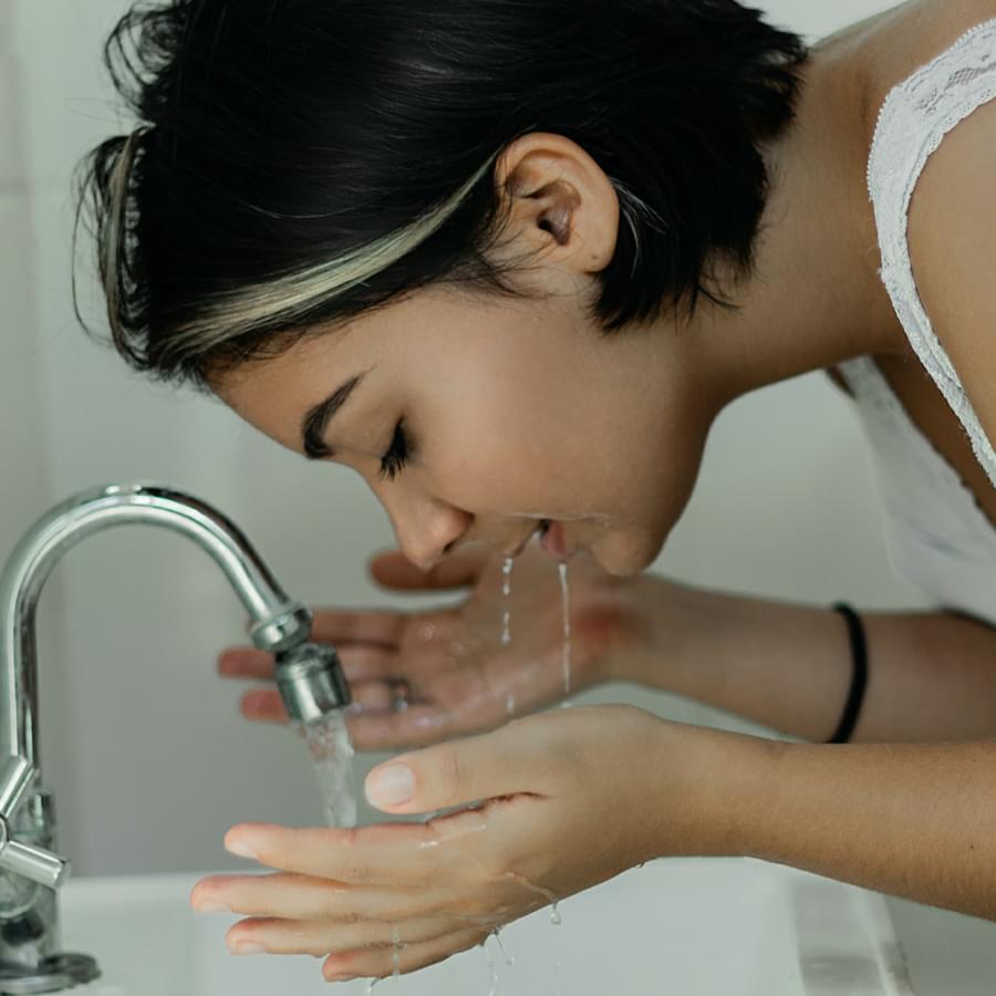 How to take care of oily skin: woman washing her face