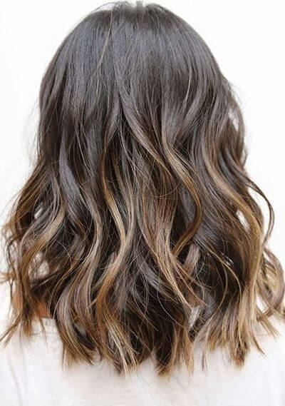Medium length wavy hair with subtle golden highlights