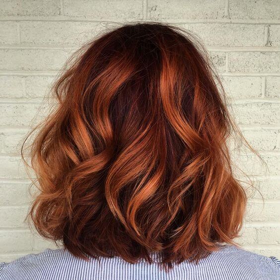 Spruce up your spring look with a burst of red - this short red wavy cut uses both light and dark copper tones