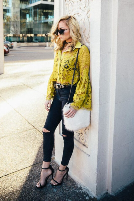 Trendy blonde in a lacy chartreuse blouse with bell sleeves and black ripped skinny jeans. A mix of delicate lace, bell sleeves, and bold chartreuse makes this statement blouse a style winner.