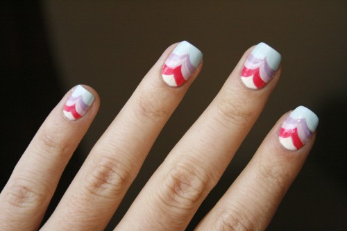 Prepare to hit the beach with some wave-inspired nail art. This artist has incorporated white, red, pink, purple, and light blue layers in her wave design, but you could use any of your favorite colors.