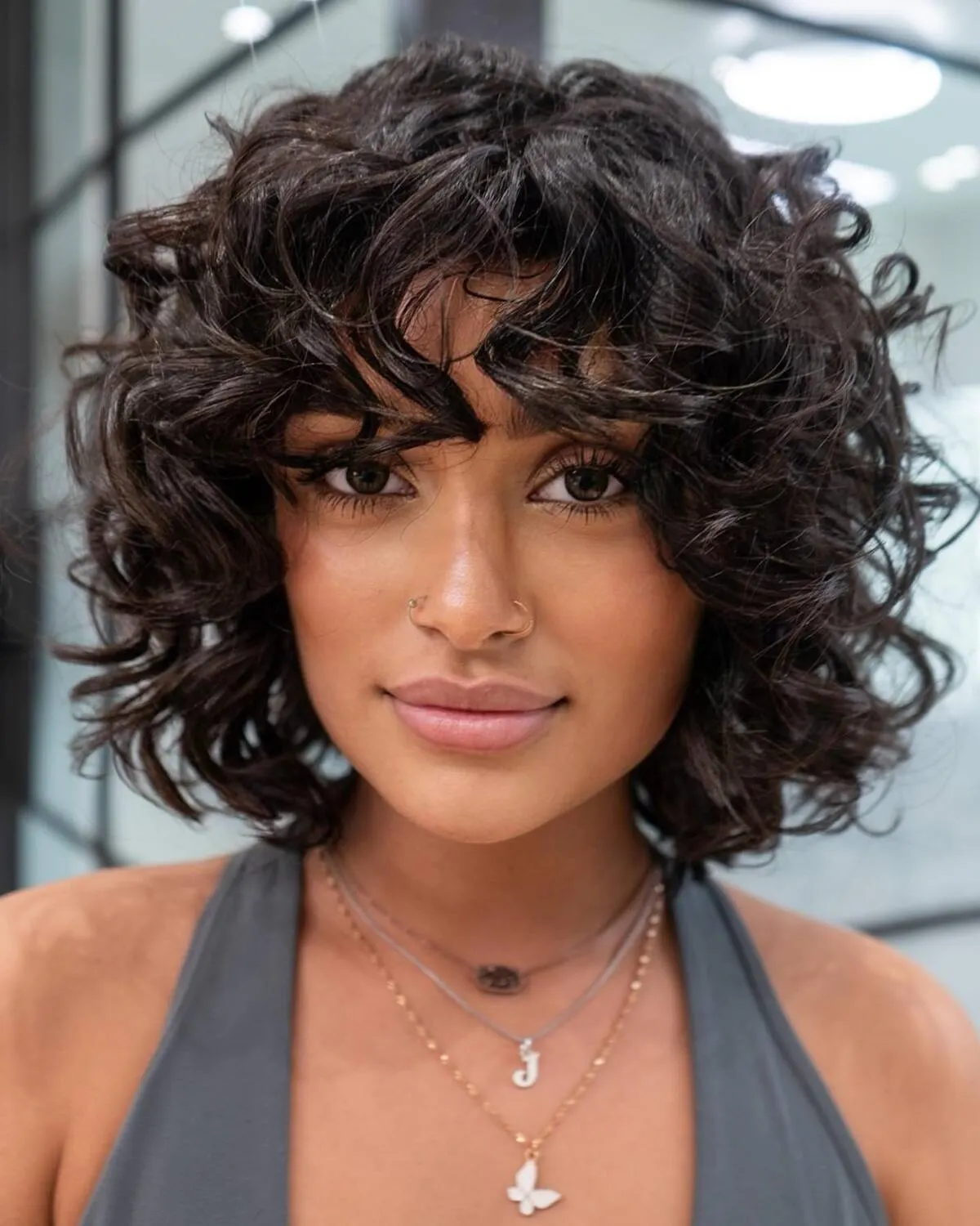 Image of Woman with curly hair and super short blunt cut