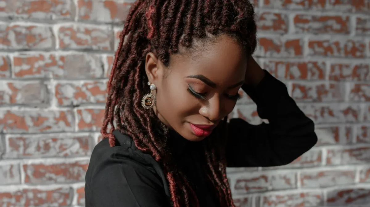 A portrait of pretty African woman with dreadlocks faux locs hairdo and stylish makeup