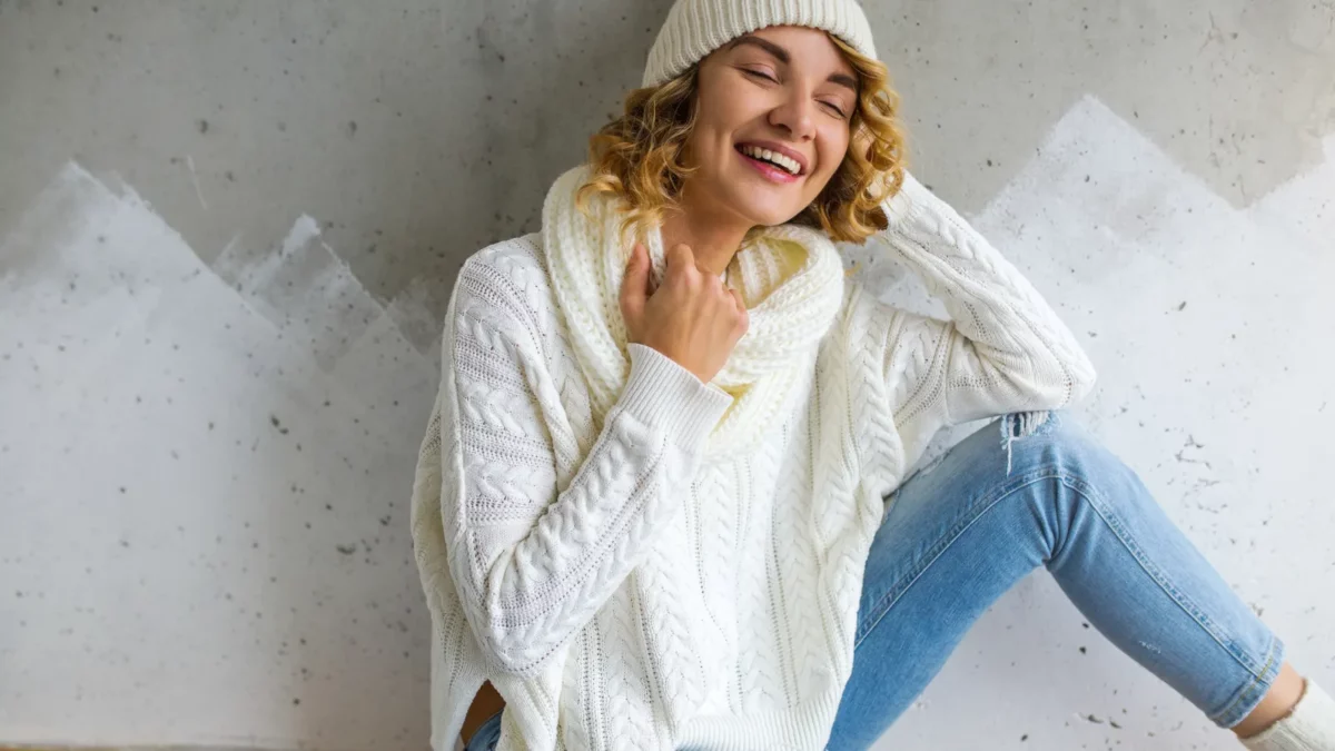 A beautiful young woman wearing white sweater and jeans