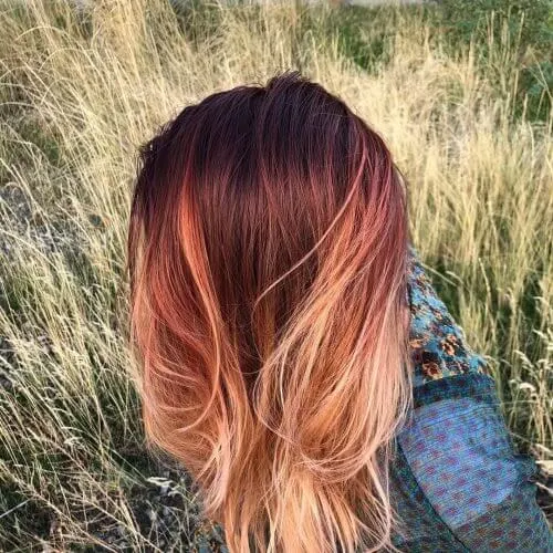 Let your hair be a canvas of fall. Dark red auburn colors melt into bright blonde ends.