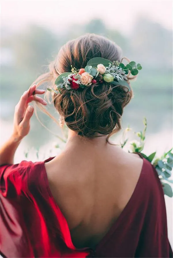 Greenery and flowers adorned in a hair updo