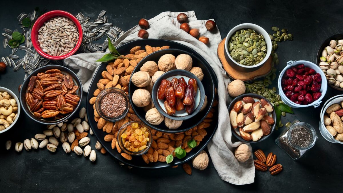 Different types of nuts, seeds and dried fruits  on black background. foods high in vegan protein, vitamins and antioxidants for immune system boosting. Top view