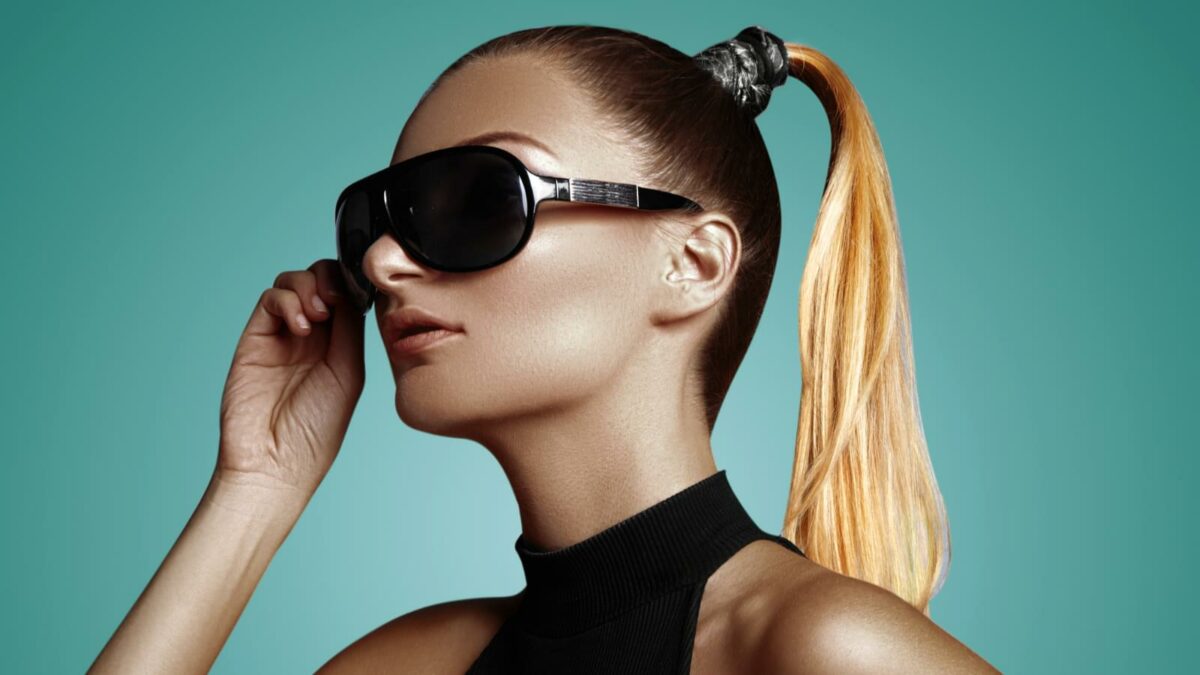 Beautiful young woman with black fashion sunglasses and glamour ponytail hairstyle.