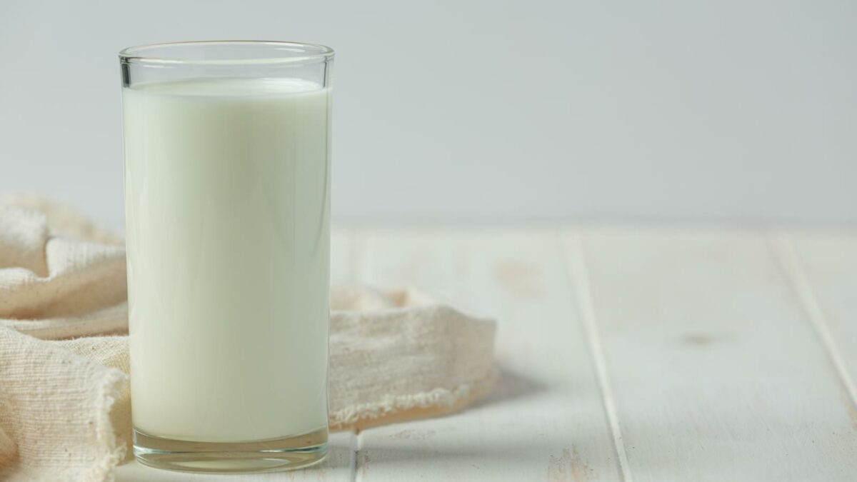 glass and bottle of milk on white wooden backgroud