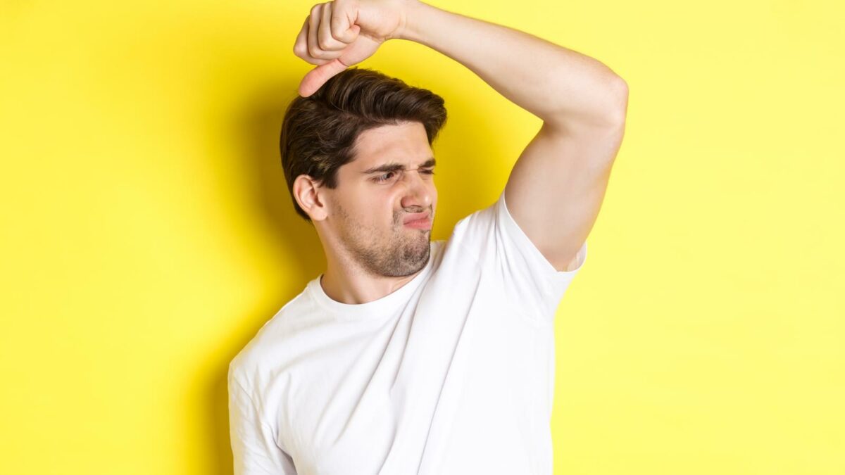Man in sweat smelling his armpit