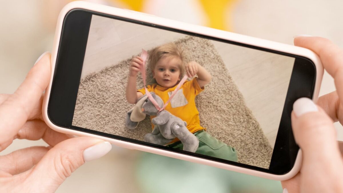 Hands with smartphone making video or phone of her son
