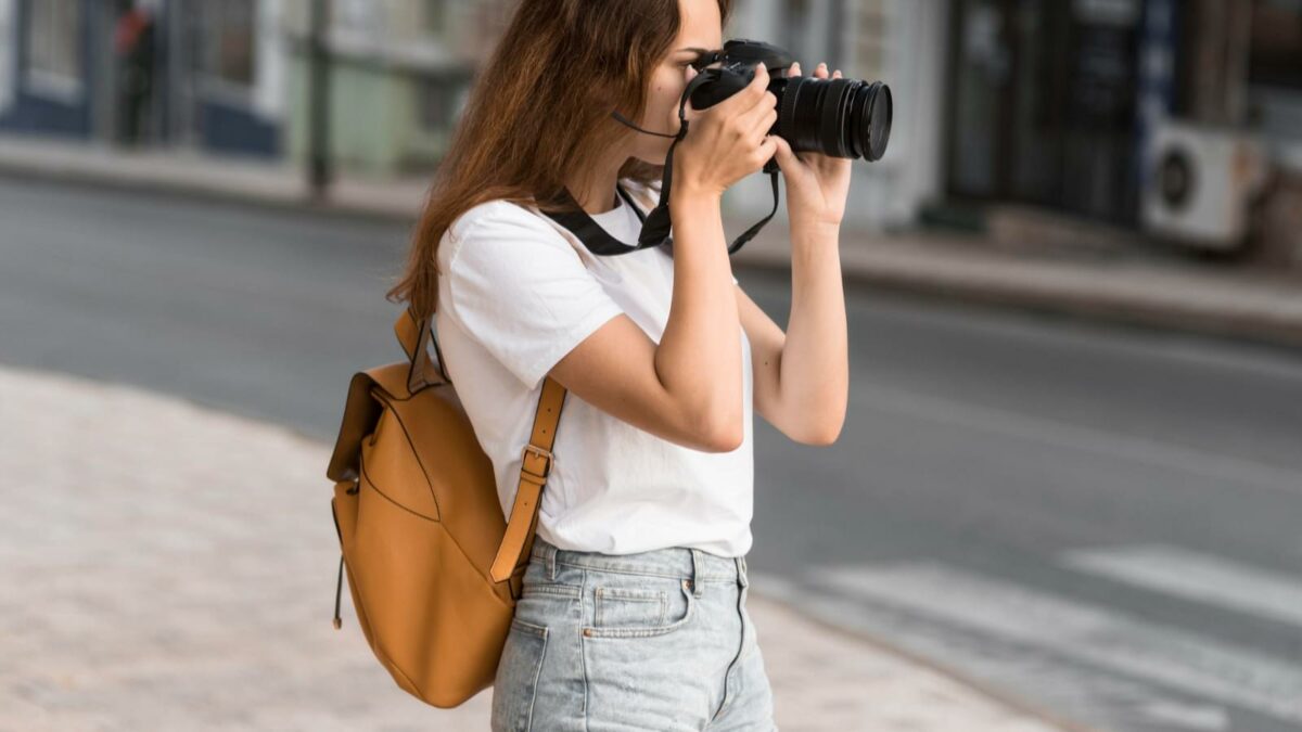 Woman with a camera bag taking pictures