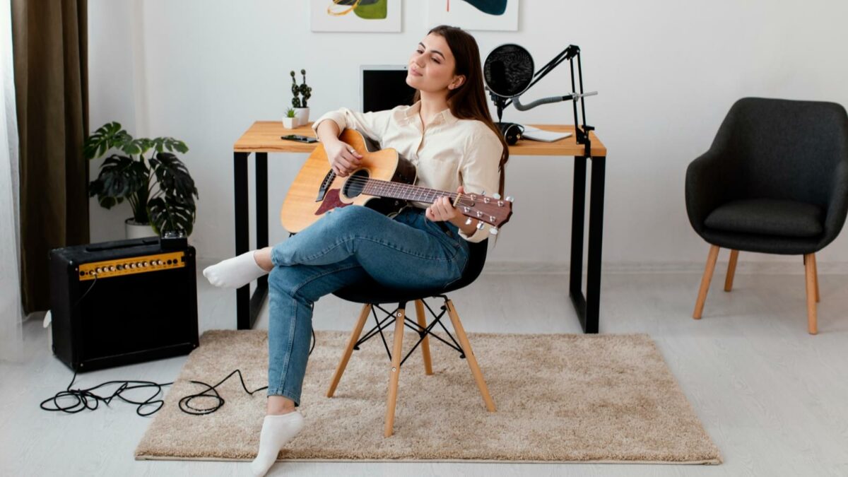 Woman playing acoustic guitar at home