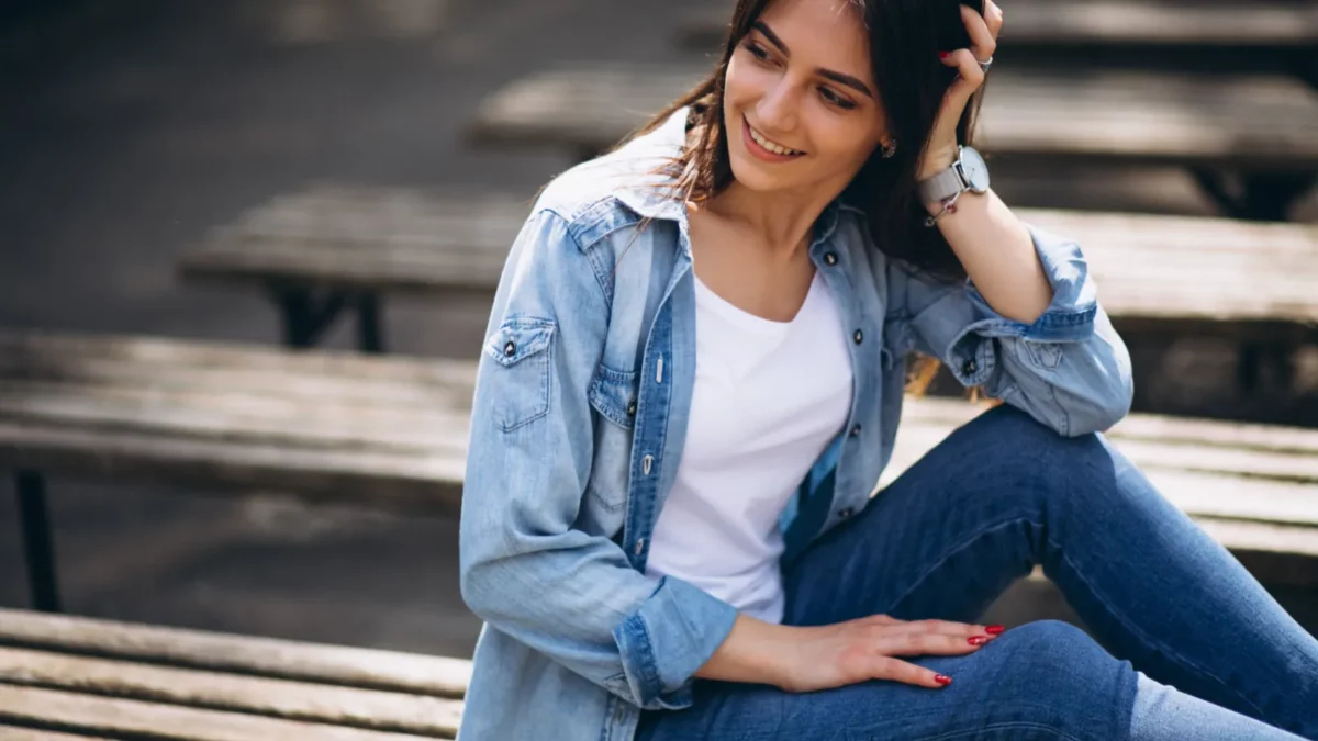 Woman sitting in the park, wearing blue jeans