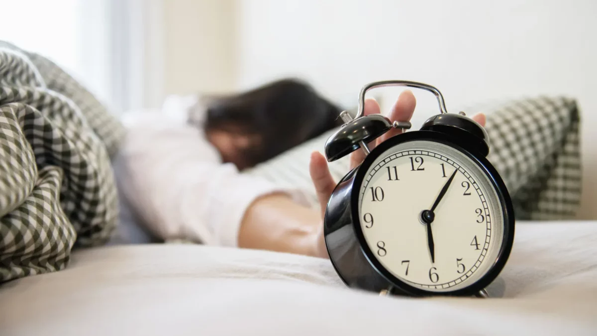 Woman reaching alarm clock