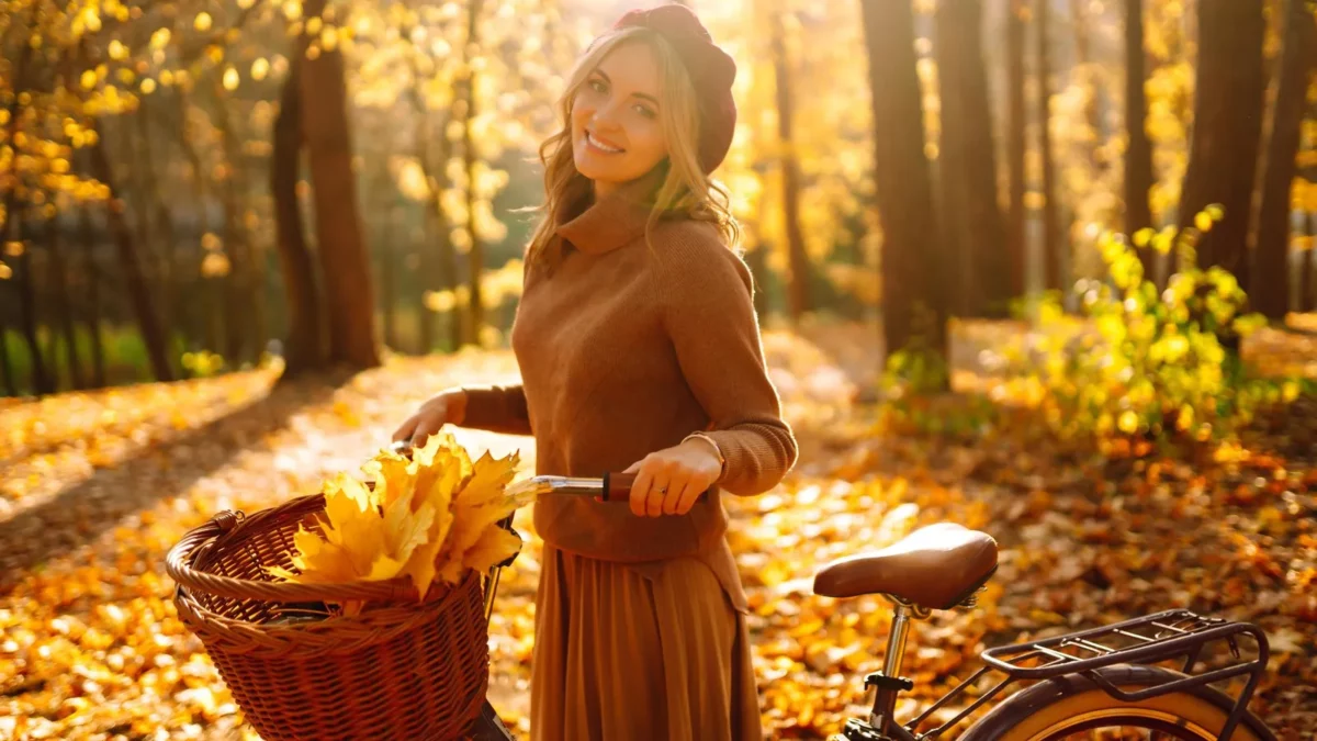 Woman with bicycle enjoying autumn weather