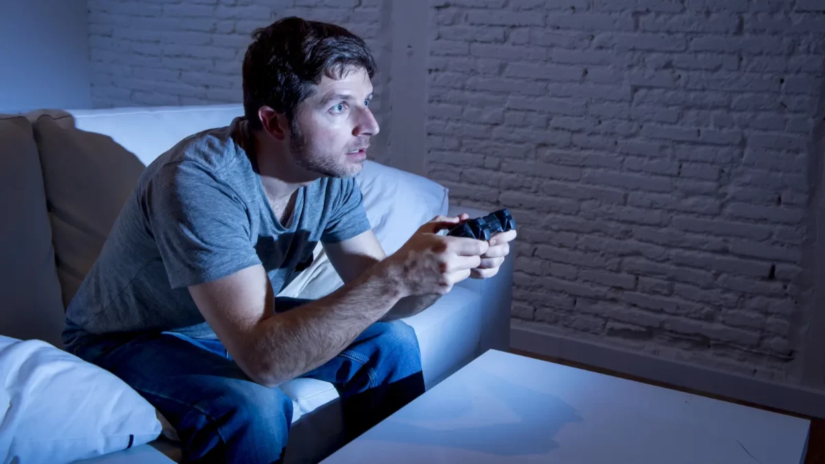 Young man at home playing video games on console