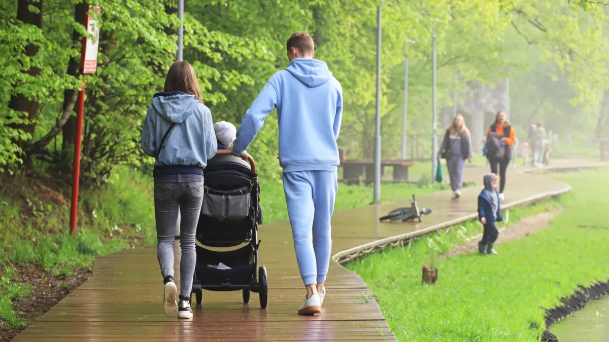 Couple with baby pram walking in a park