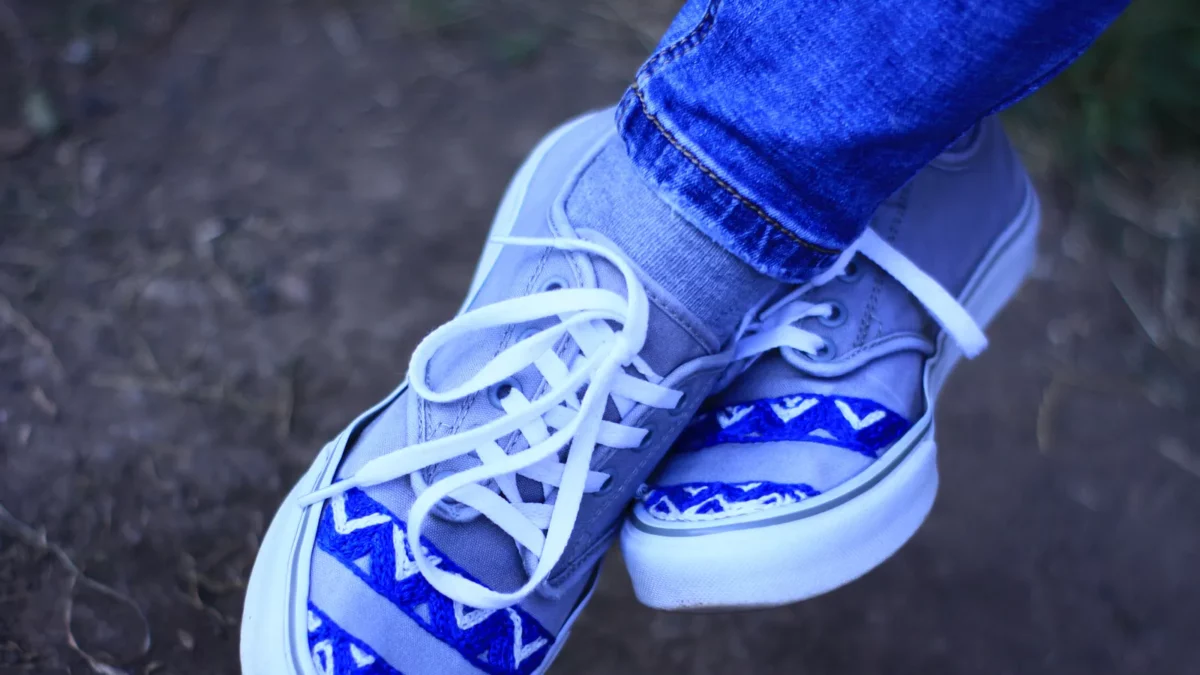 Handmade sneakers on legs with jeans