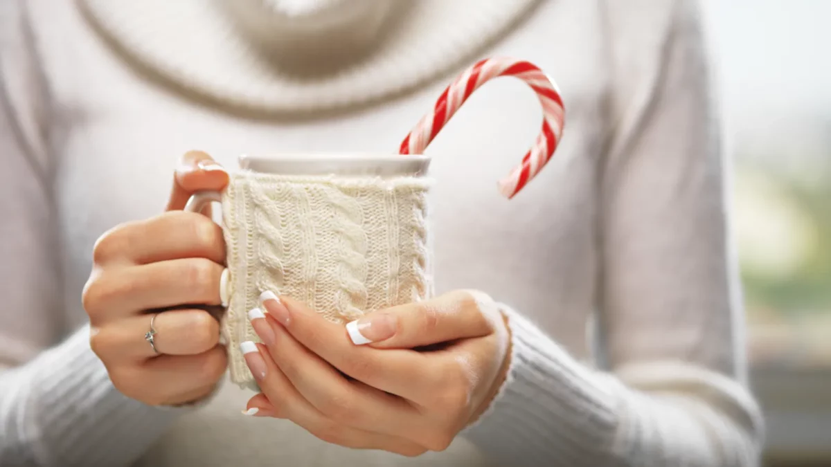 Woman holds a winter cup, French manicure square nails