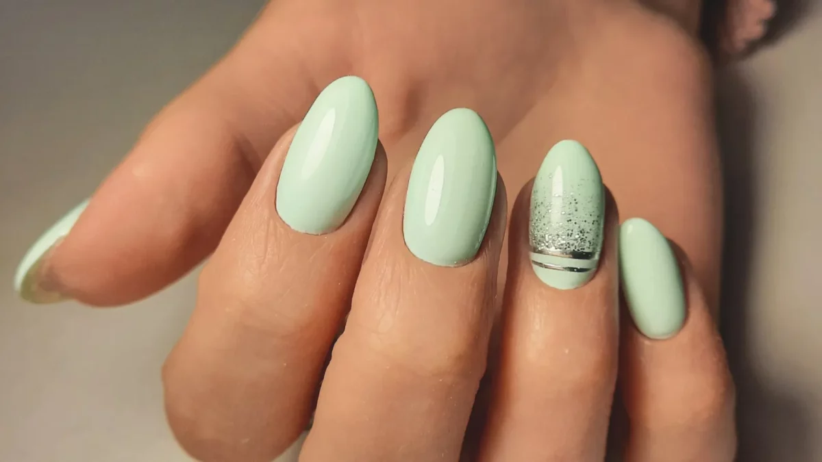 Gentle gel polish of pale turquoise color on almond-shaped nails