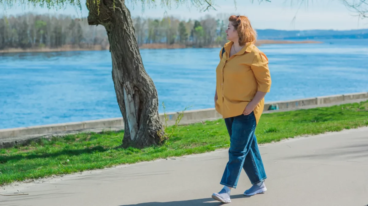 Woman walking in the park, wearing blue jeans