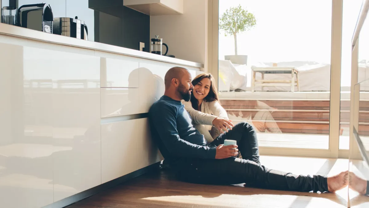 Man and woman sitting on floor in kitchen