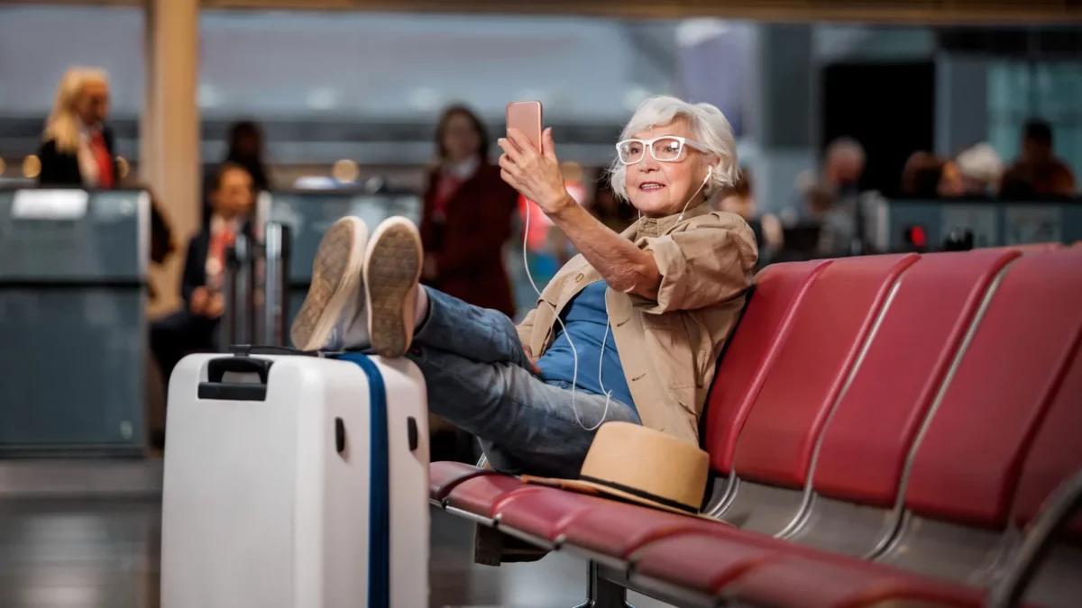 Old lady is sitting at airport lounge