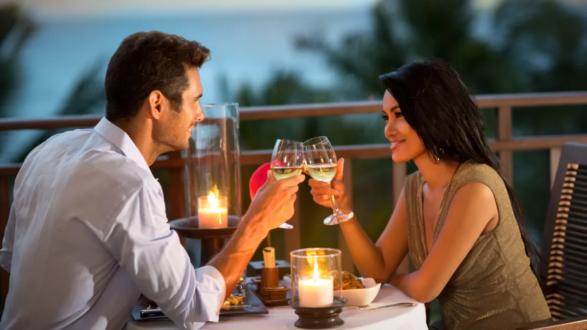 Romantic couple toasting during dinner on tropical resort
