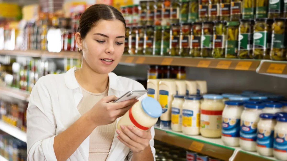 Woman chooses mayonnaise in supermarket